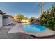The backyard features a pool with a rock waterfall and stone landscaping for added beauty at 6771 Shelter Ln, Las Vegas, NV 89103