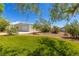 Lush backyard with mature trees, grassy area, and detached garage at 6908 Bienville St, Las Vegas, NV 89131