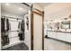 Bathroom featuring a walk-in closet, dual sinks, shiplap, modern fixtures, and marble shower at 6908 Bienville St, Las Vegas, NV 89131