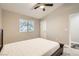 Bedroom with dark bed frame, ceiling fan, window, and access to another room at 6908 Bienville St, Las Vegas, NV 89131