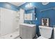Modern bathroom features blue walls and a shower with white tile surround at 7 Sturm St, Henderson, NV 89015