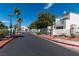 A neighborhood entrance features a well-maintained road, mature trees, and a neighborhood sign at 7100 Pirates Cove Rd # 2065, Las Vegas, NV 89145