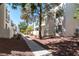 View of modern townhouse exteriors with neat landscaping and walkways under a clear blue sky at 7100 Pirates Cove Rd # 2065, Las Vegas, NV 89145
