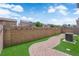 A manicured backyard featuring artificial grass, a brick paver pathway, and a block fence provides outdoor appeal at 7257 Early Pioneer Ave, Las Vegas, NV 89129