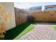 Charming backyard with brick-paved walkway, artificial turf, and decorative string lights, perfect for relaxing at 7257 Early Pioneer Ave, Las Vegas, NV 89129