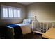 Charming bedroom with a white bed and crib set, complemented by soft blue accents for a peaceful feel at 7257 Early Pioneer Ave, Las Vegas, NV 89129