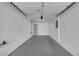 An attached two car garage with white walls, concrete floors, and overhead lighting provides functional space at 7257 Early Pioneer Ave, Las Vegas, NV 89129