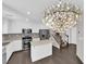 Modern kitchen with white cabinets, stainless steel appliances, and a center island with dark wood floors at 7257 Early Pioneer Ave, Las Vegas, NV 89129