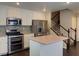 Updated kitchen with stainless appliances, island, and staircase at 7257 Early Pioneer Ave, Las Vegas, NV 89129