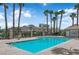 Community pool with palm trees, a bath house, and a serene water feature for resident enjoyment at 7257 Early Pioneer Ave, Las Vegas, NV 89129