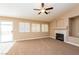 Cozy living room with a fireplace, slider to patio and carpet flooring at 8205 Harrogate Ave, Las Vegas, NV 89129