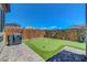 Backyard with artificial turf putting green, enclosed by a wooden and bamboo fence for added privacy at 8958 Howell St, Las Vegas, NV 89166