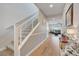 Bright foyer with hardwood floors and modern staircase. Living room visible in background at 8958 Howell St, Las Vegas, NV 89166