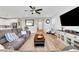 Open-concept living room boasts wood floors, modern fixtures, comfortable seating, and seamless flow to other spaces at 8958 Howell St, Las Vegas, NV 89166