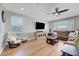 Spacious living room featuring wood floors, comfortable seating, ample natural light, and a modern ceiling fan at 8958 Howell St, Las Vegas, NV 89166