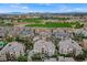 A bird's eye view of a luxurious condo complex bordering a golf course, with mountains and city buildings in the far distance at 9201 Tesoras Dr # 401, Las Vegas, NV 89144