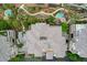 Aerial top-down view of the condo complex rooftops with desert landscaping, walkways, mature trees, and private community pools at 9201 Tesoras Dr # 401, Las Vegas, NV 89144