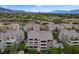Lovely aerial view of condos in a golf course community, featuring desert landscaping and a mountain range backdrop at 9201 Tesoras Dr # 401, Las Vegas, NV 89144
