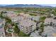 Stunning aerial view of a condo complex with lush landscaping and beautiful mountain views in the background at 9201 Tesoras Dr # 401, Las Vegas, NV 89144
