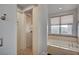 Bright bathroom with a glass shower, a drop-in tub with natural light from a window at 9201 Tesoras Dr # 401, Las Vegas, NV 89144