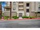 Exterior view of building entrance with mature landscaping and visible unit numbers at 9201 Tesoras Dr # 401, Las Vegas, NV 89144