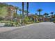 Paver entrance road leading to community entry with palm trees and lush landscaping at 9201 Tesoras Dr # 401, Las Vegas, NV 89144
