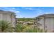 This exterior view shows two buildings, palm trees, and a view of a golf course at 9201 Tesoras Dr # 401, Las Vegas, NV 89144