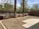 A backyard featuring rock landscaping, a concrete walking path, and palm trees with a wall and fence at 9236 Canalino Dr, Las Vegas, NV 89134