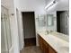 Bathroom featuring double sinks, quartz countertop, a large mirror, and a glass shower at 9236 Canalino Dr, Las Vegas, NV 89134