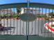 Community entrance gate, featuring an 'SB' logo, manicured landscaping, and red paved streets at 9236 Canalino Dr, Las Vegas, NV 89134