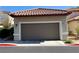 A single Gathering home featuring an attached 2-car garage, painted in a neutral color, and a red tiled roof at 9236 Canalino Dr, Las Vegas, NV 89134