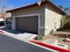 Neutral colored home featuring an attached two-car garage with painted trim, a tiled roof, and desert landscaping at 9236 Canalino Dr, Las Vegas, NV 89134