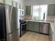 Updated kitchen featuring stainless steel appliances, a view from the window, and sage green cabinets at 9236 Canalino Dr, Las Vegas, NV 89134