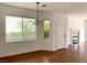 A sunlit living room featuring wood floors, a modern chandelier, and a cozy fireplace at 9236 Canalino Dr, Las Vegas, NV 89134