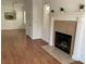 Inviting living area with fireplace, wood flooring, and view into the kitchen with sage green cabinets at 9236 Canalino Dr, Las Vegas, NV 89134