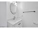 Bathroom featuring an oval mirror, white vanity, and modern fixtures against a clean, neutral backdrop at 9247 Tulip Trestle Ave, Las Vegas, NV 89148