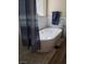Freestanding tub featuring deck-mounted faucet and blue stripped shower curtain in tiled bathroom at 9589 Comiskey Ct, Las Vegas, NV 89148