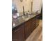 This kitchen features granite counters, a stainless sink, and dark wood cabinets at 9589 Comiskey Ct, Las Vegas, NV 89148
