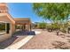 Well-maintained backyard with desert landscaping, a covered patio, and views of the surrounding area at 9800 Rosamond Dr, Las Vegas, NV 89134