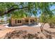 Inviting backyard with desert landscaping, mature trees, and a covered patio area at 9800 Rosamond Dr, Las Vegas, NV 89134