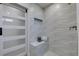 Contemporary shower with white wavy tile, a built-in bench, and glass sliding door at 9800 Rosamond Dr, Las Vegas, NV 89134