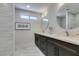 Modern bathroom featuring a double vanity, sleek mirrors, and stylish marble floors at 9800 Rosamond Dr, Las Vegas, NV 89134