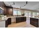 Bright kitchen with granite countertops, dark wood cabinets, and natural light from large windows at 9800 Rosamond Dr, Las Vegas, NV 89134