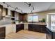 Modern kitchen featuring granite countertops, dark wood cabinets, and stainless steel appliances at 9800 Rosamond Dr, Las Vegas, NV 89134