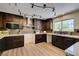 Well-appointed kitchen with modern appliances, dark cabinets, granite countertops, and track lighting at 9800 Rosamond Dr, Las Vegas, NV 89134