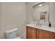 Half bath with a marble counter and wood cabinet at 9893 Santa Ponsa Ct, Las Vegas, NV 89178