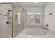 Bright bathroom featuring a tub, shower, and marble walls at 9893 Santa Ponsa Ct, Las Vegas, NV 89178