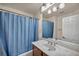 Bathroom with a marble countertop and a blue shower curtain at 9893 Santa Ponsa Ct, Las Vegas, NV 89178