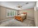 Bedroom with a wooden bed frame, a ceiling fan, and large windows offering ample natural light at 9893 Santa Ponsa Ct, Las Vegas, NV 89178
