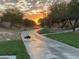 Scenic community pathway with a walking path, landscaping, and a beautiful sunrise at 9893 Santa Ponsa Ct, Las Vegas, NV 89178